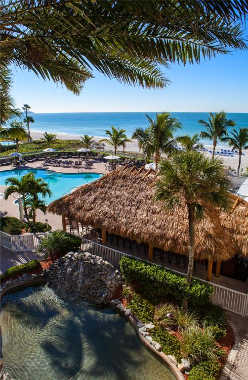 Thatched-roof tiki bar beside the pools and Gulf beach at Lido Beach Resort.