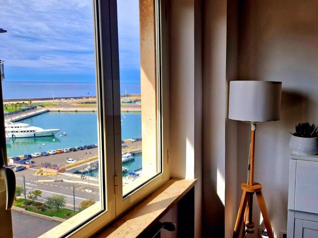 a window in a room with a view of a harbor at Santa Maria Apartment in Civitavecchia