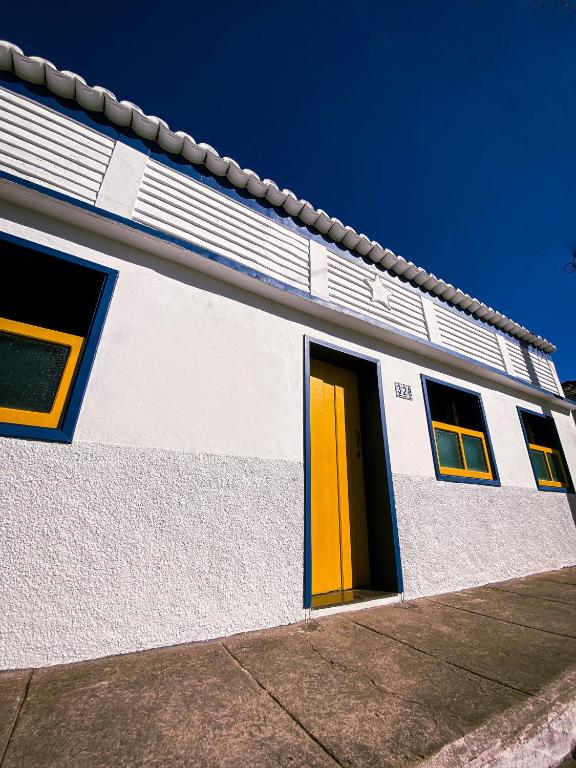 オウロ・プレットにあるRecanto do Sol - Lavras Novasの黄色の扉のある白と黄色の建物