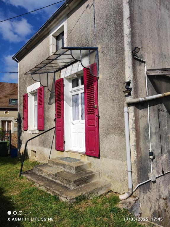 une maison avec des portes rouges et des marches devant dans l'établissement Maison de vacances individuelle toute équipée, à Dampierre-sous-Bouhy