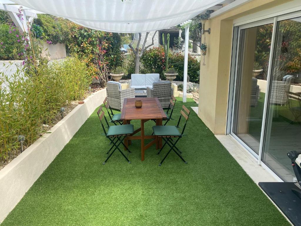 un patio avec une table et des chaises sur l'herbe dans l'établissement Chez Valentine, à Nice