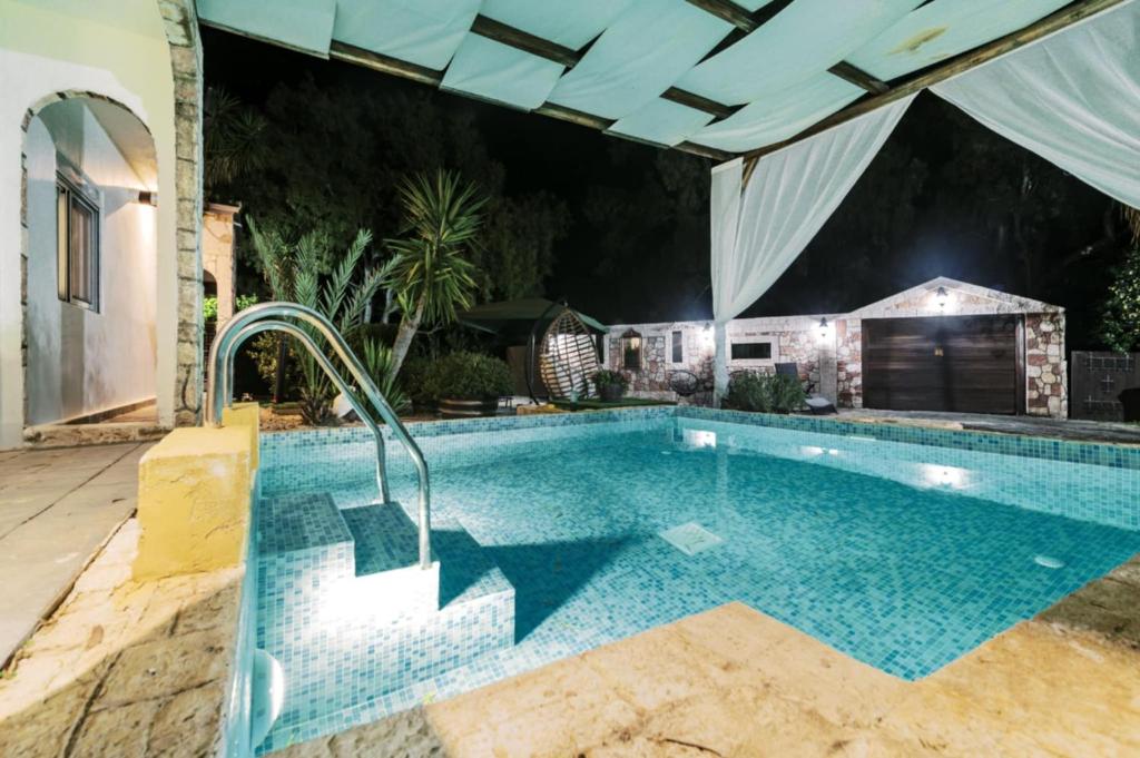 a swimming pool in a backyard with a house at Bella Terra Villa Filerimos in Rhodes Town