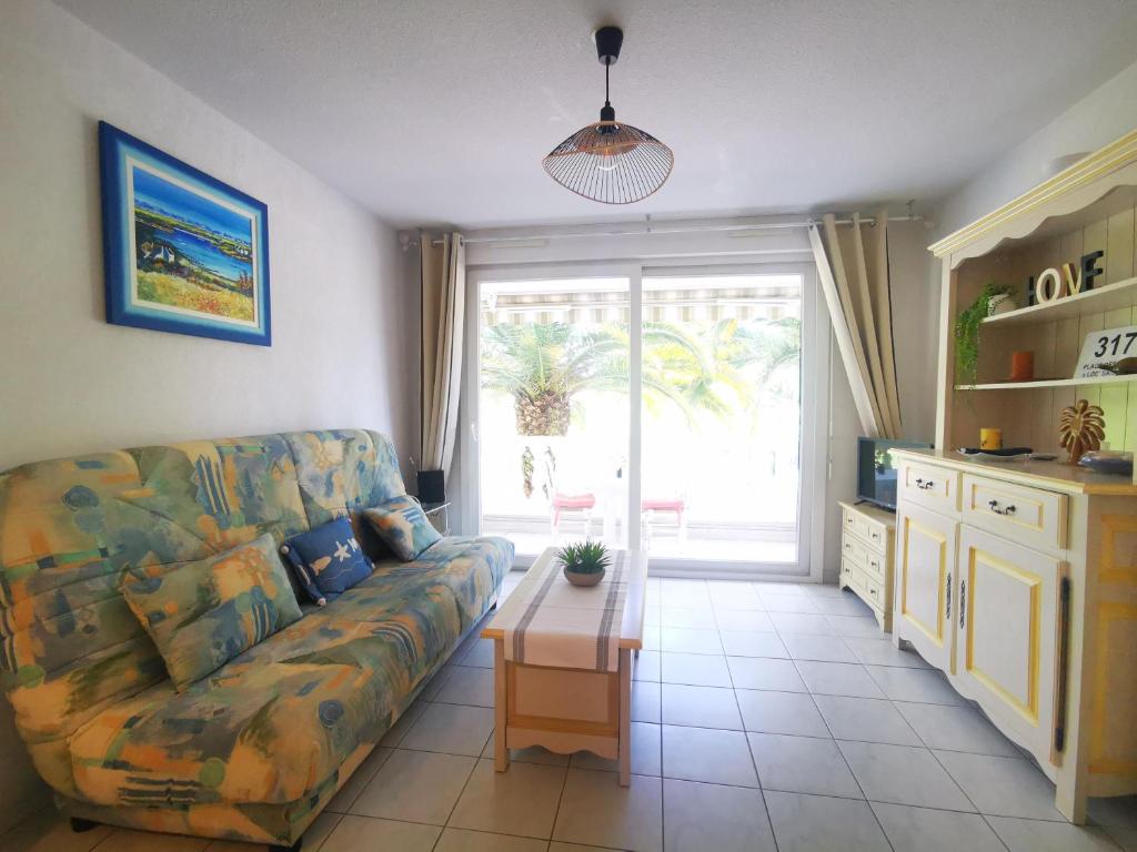 un salon avec un canapé et une table dans l'établissement Le Tropical - 4 Pers - Ensoleillé, à Fréjus