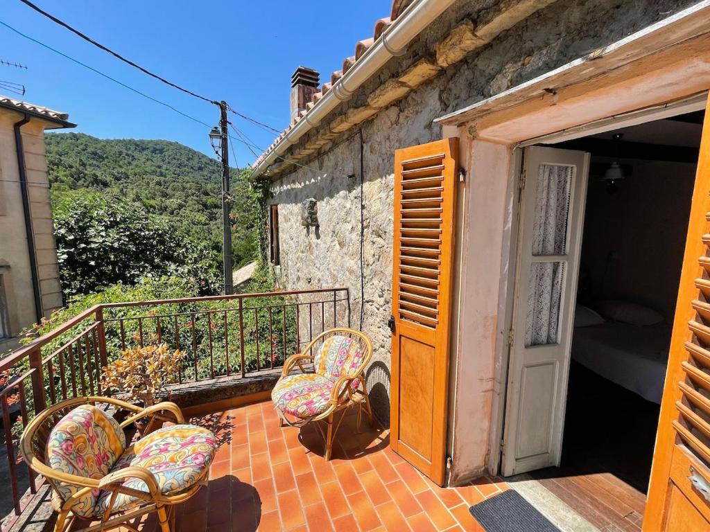 - un ensemble de chaises assises sur un balcon dans l'établissement Charmante maison authentique et au calme, à Tavera