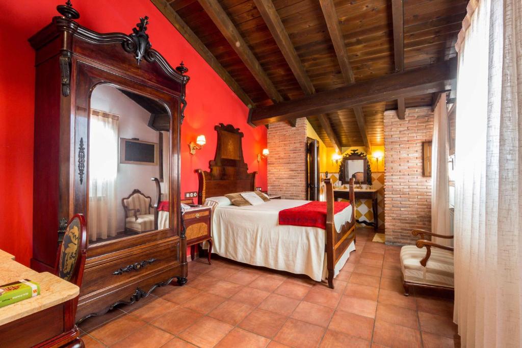 a bedroom with a bed in a room with red walls at Hotel La Realda in Gea de Albarracín