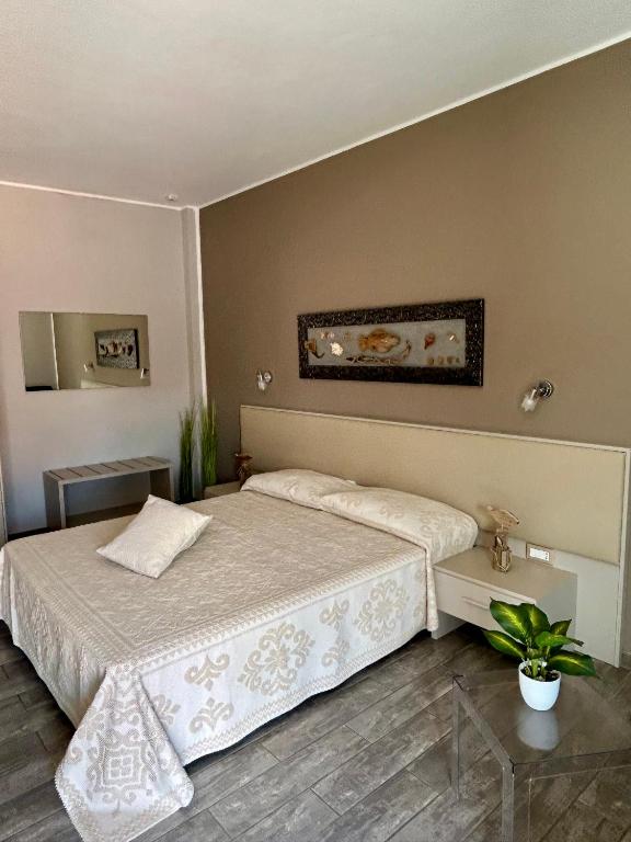 a bedroom with a large bed and a table at La Locanda di Piazza in Santa Teresa Gallura