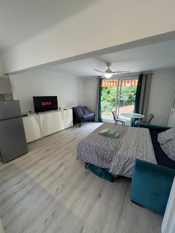 une chambre avec un lit, une table et des chaises dans l'établissement Grand Studio Lumineux et Fonctionnel 4 couchages Gare routière, à Menton