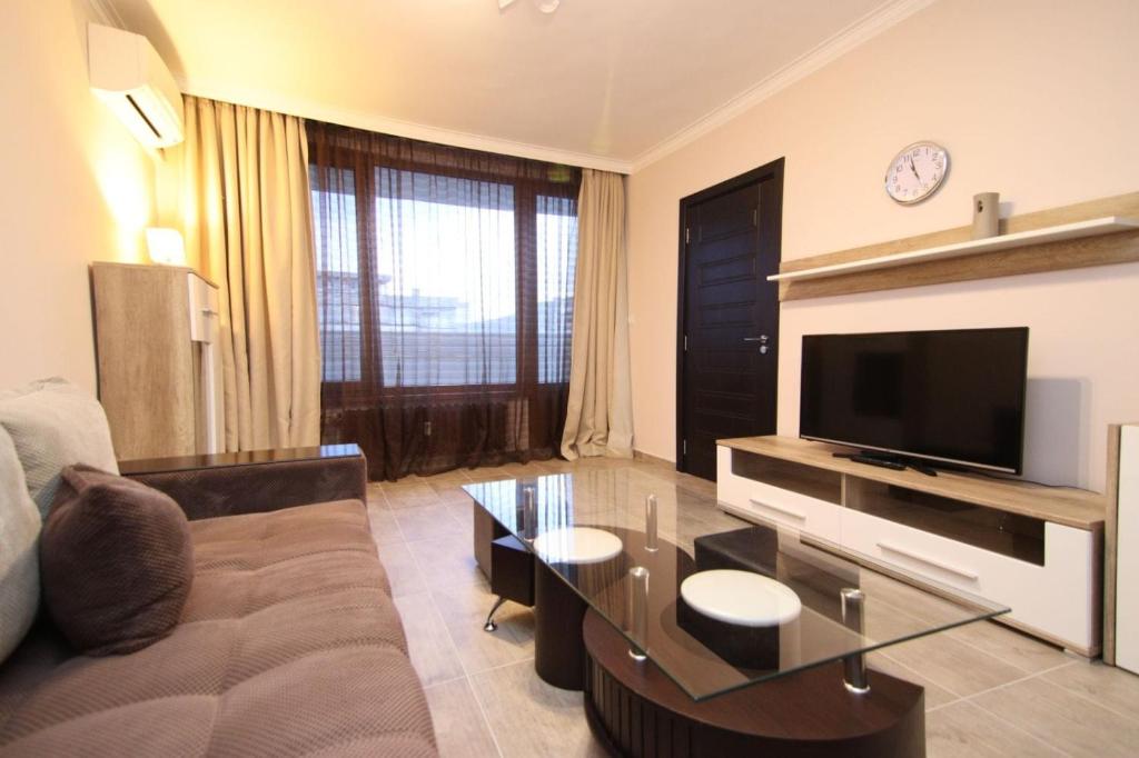 a living room with a couch and a flat screen tv at Parkzicht Gent in Ghent