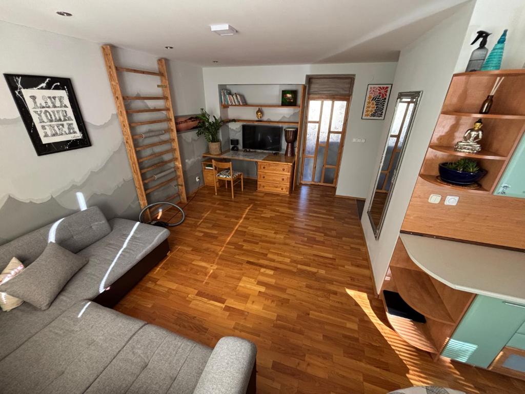 a living room with a couch and wooden floors at apartmán minimal in Spišská Nová Ves