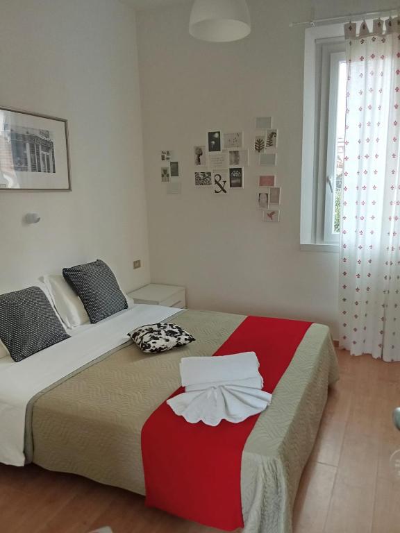 a bedroom with a bed with a red and white blanket at Hotel Migani in Rimini