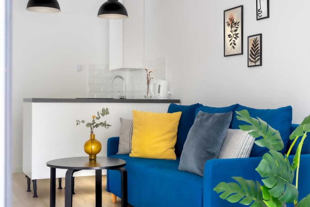 a blue couch in a living room with a table at Apartament TU Cichowo in Cichowo