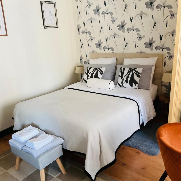 - une chambre avec un lit blanc et un papier peint floral dans l'établissement Studio chic de Sophie plein cœur du centre-ville, à Honfleur