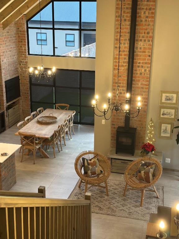 a dining room with a table and chairs and a fireplace at Fallen Oak Villa 1 in George