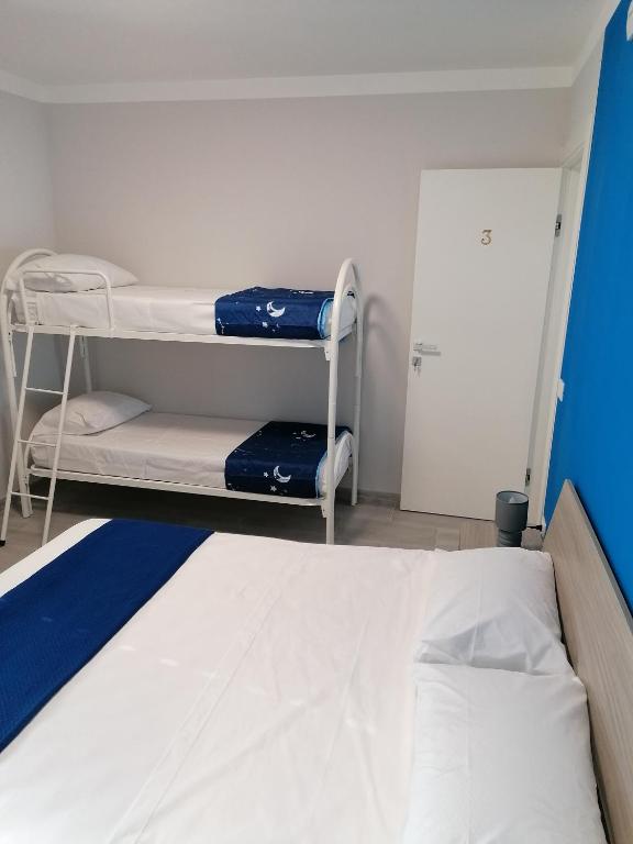 a room with two bunk beds and a door at Villa Porto fossa in Marzamemi