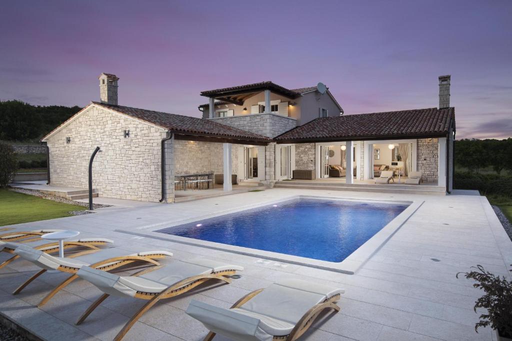 a villa with a swimming pool in front of a house at Heritage Villa Lilly in Krnica
