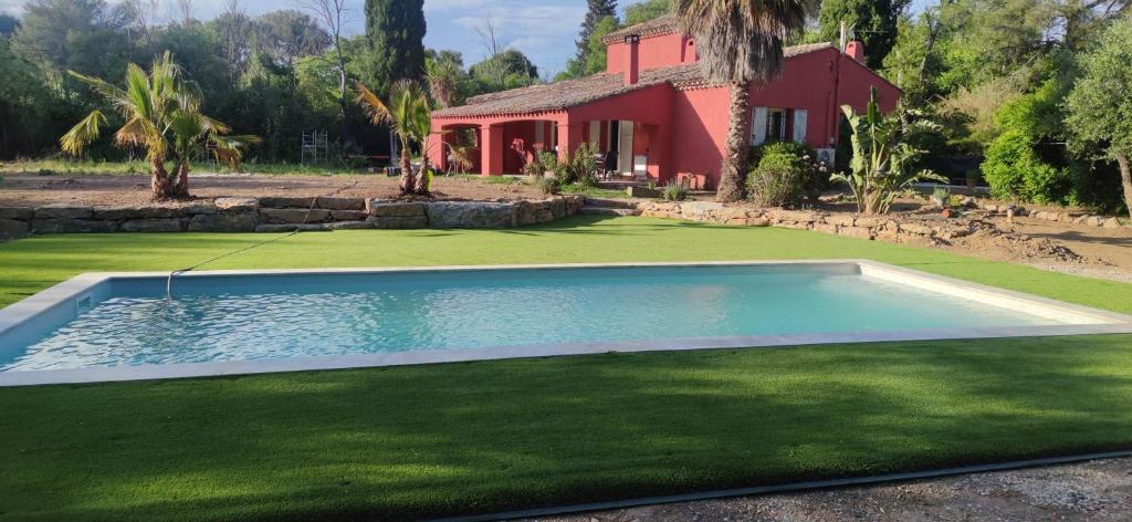a swimming pool in front of a house at Villa Katiramona in Le Muy