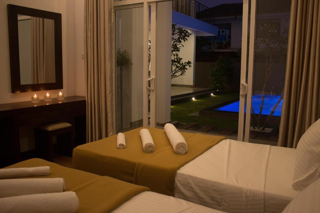 a bedroom with a bed and a view of a balcony at The Suite 262 in Negombo