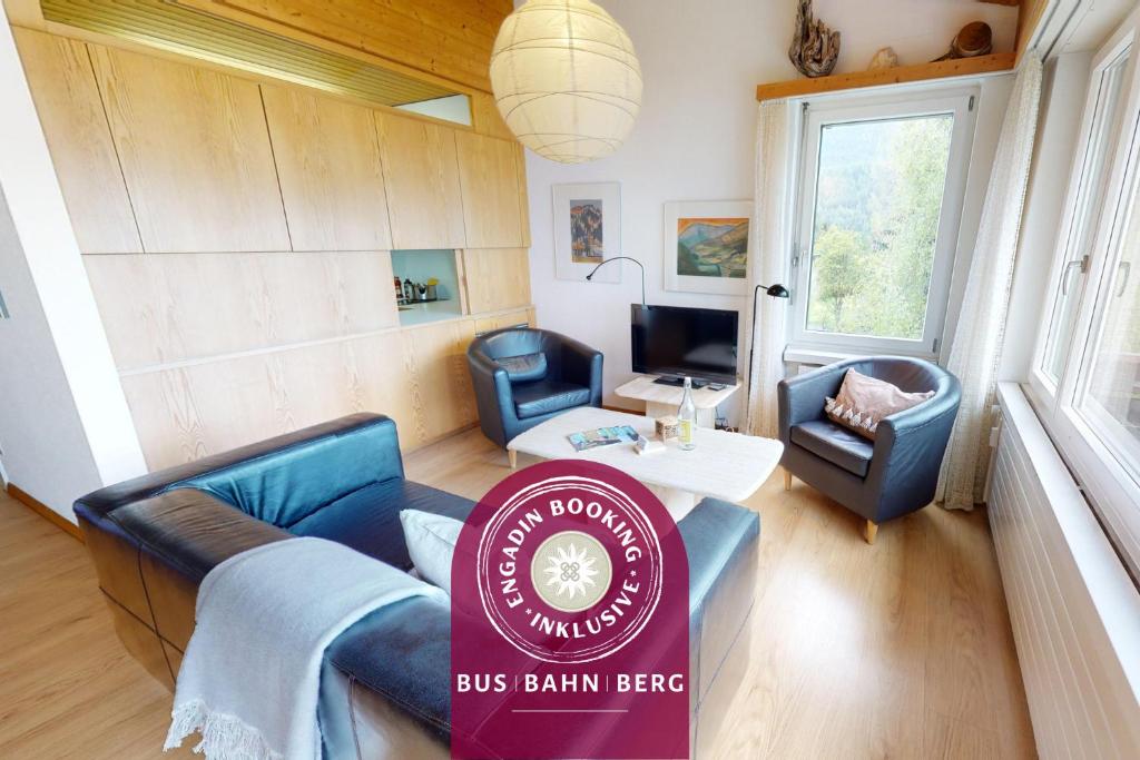 Una sala de estar con un cartel de "Bus Britain Meat" en una habitación. en Feriensiedlung Trü 7, en Scuol