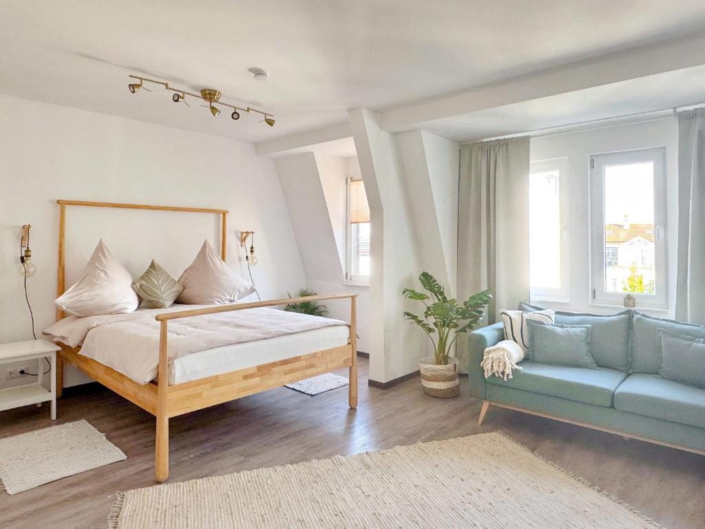 a bedroom with a bed and a couch at Deichstadt Apartments in Neuwied