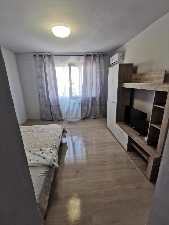 a small room with two beds and a television at GARSONIERĂ in Arad