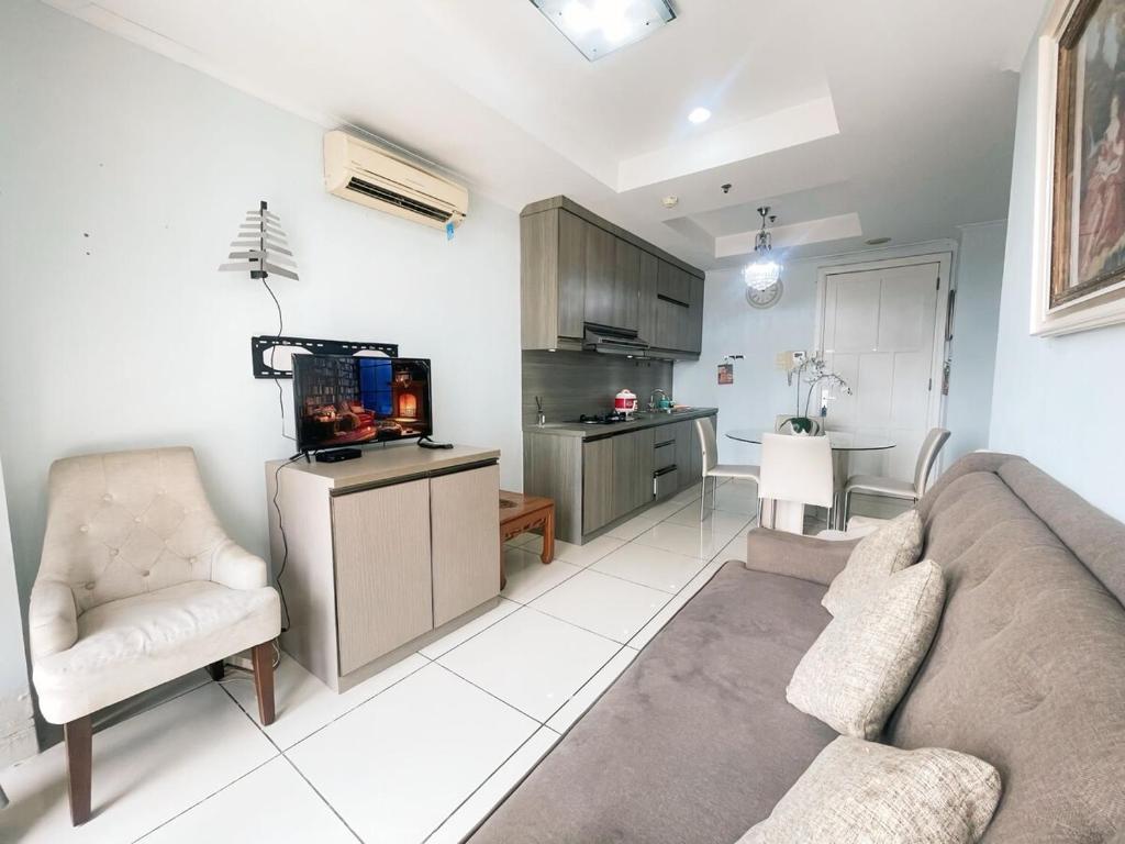 un soggiorno con un divano e una TV di Cozy and Stategic 1 at cikditiro 2BR pool,gym,wifi By LS a Giacarta