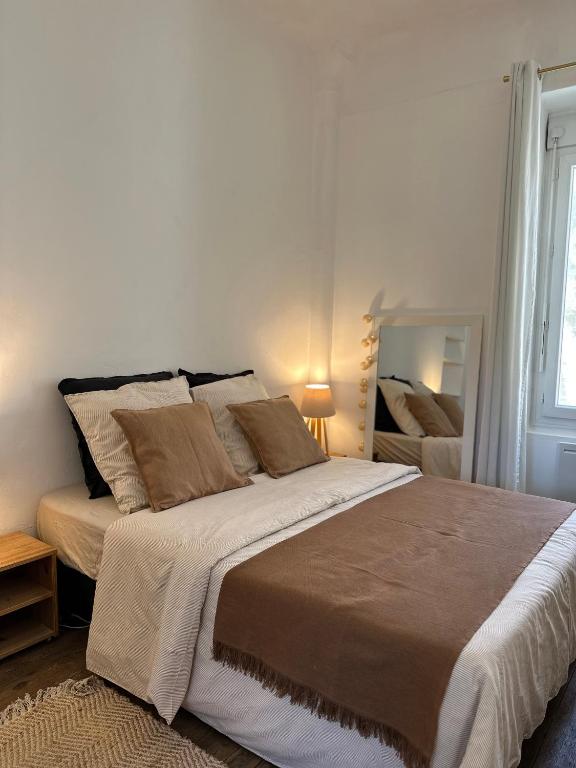 une chambre avec un grand lit et une fenêtre dans l'établissement La Maisonnette, à Nîmes