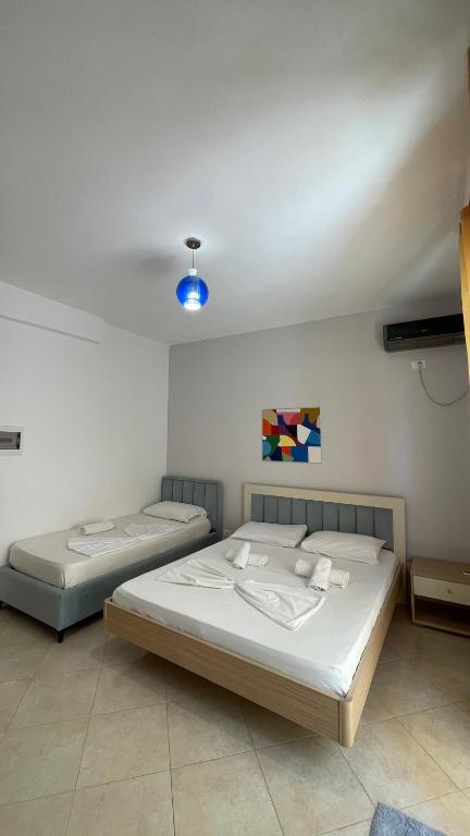 two beds in a bedroom with a blue light at The Blue Horizon in Vlorë