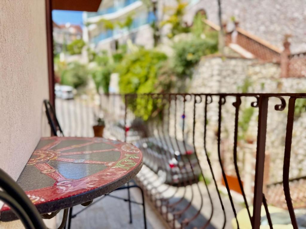 a balcony with a bench and a table on a balcony at Poet's rooms in Taormina