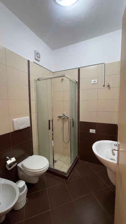 a bathroom with a shower and a toilet and a sink at The Blue Horizon in Vlorë