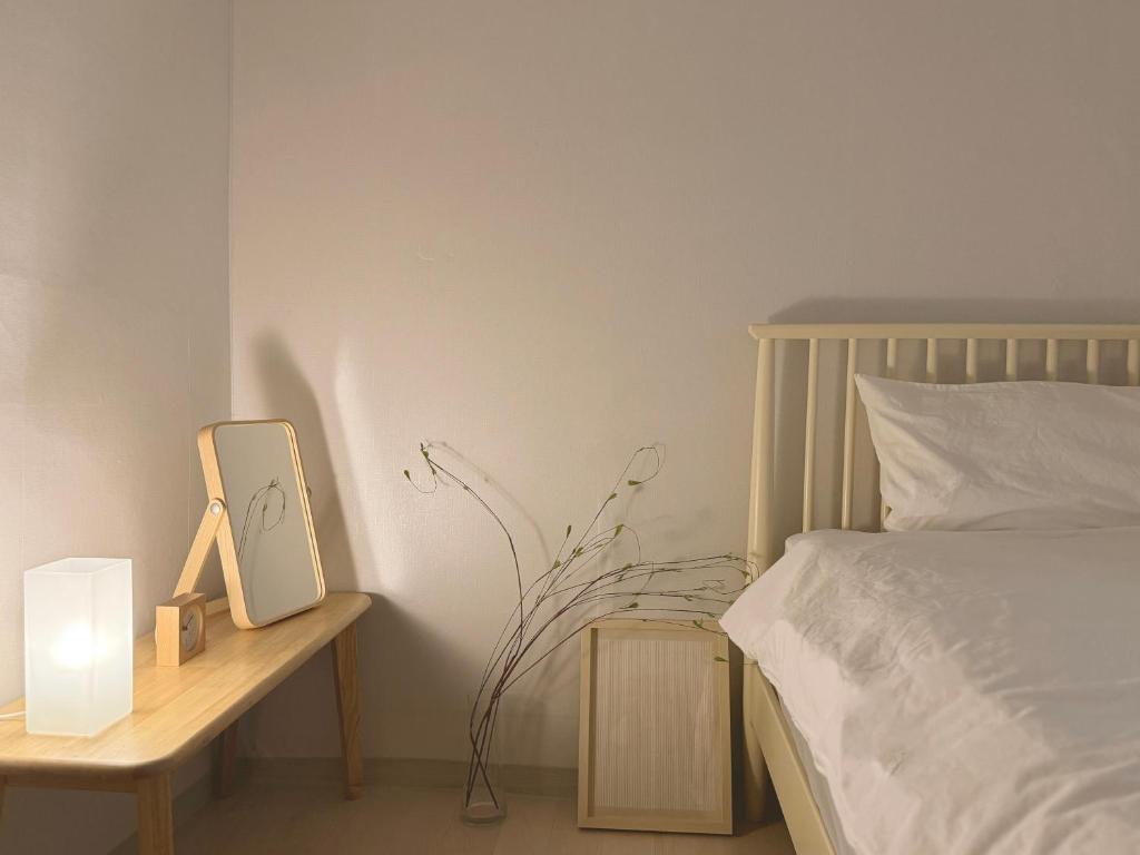 - une chambre avec un lit et une table avec une horloge dans l'établissement 'SUPUL HOUSE' Danggok Station 10 minutes, Free late checkout, à Séoul
