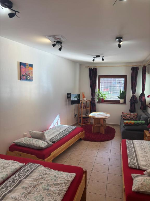 a room with three beds and a living room at Apartment Ortler in Banská Štiavnica