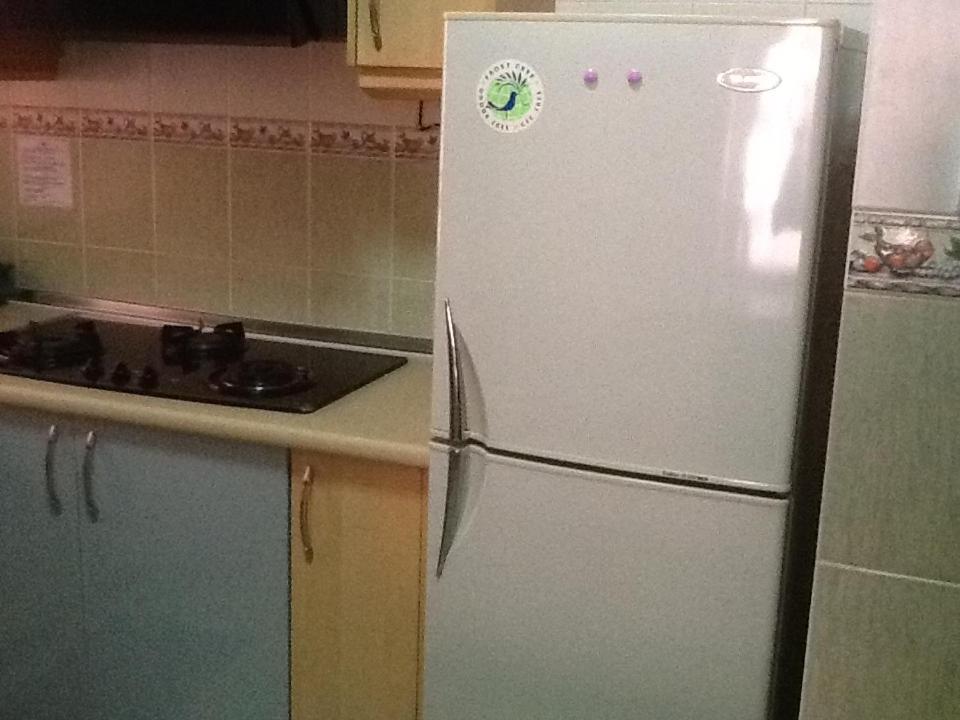 a kitchen with a white refrigerator in a kitchen at HP Vacation Marina Court in Kota Kinabalu