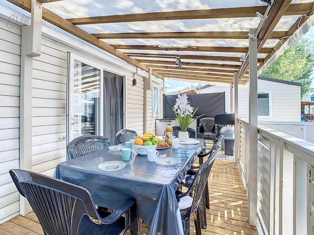 - une table bleue avec un bol de fruits sur la terrasse dans l'établissement Mobil-home VO 05 à Vias - La Carabasse - Camping Siblu avec Piscine, à Vias
