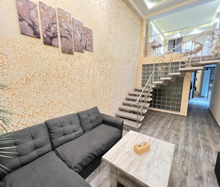 a living room with a couch and a staircase at Cozy Duplex City Center in Yerevan