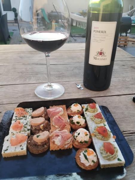 une table avec une assiette de nourriture et un verre de vin dans l'établissement Villa Sainte-Lucie, à Calvi
