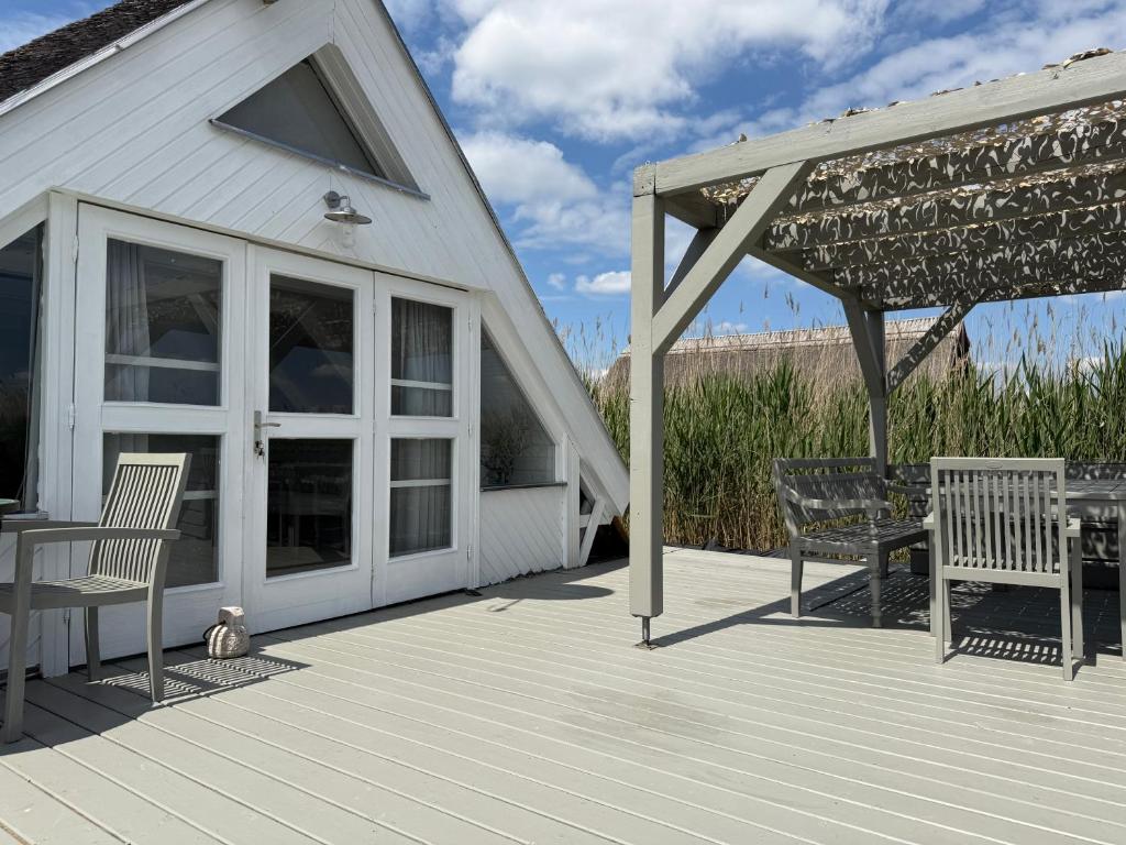 a patio with two chairs and a table on a deck at Seehütte Neusiedlersee inklusive Boot in Rust