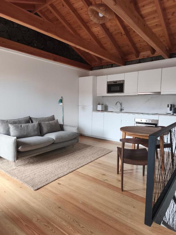 a living room with a couch and a table at Cá Por Casa Pico-Faia in Prainha de Baixo