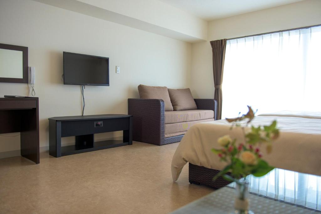 a hotel room with a bed and a couch at Condominium Hotel Monpa in Chatan