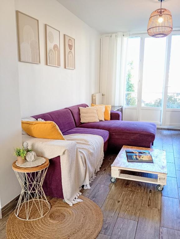 un salon avec un canapé violet et une table dans l'établissement MAS DREVON T3 Parking - Mer à 15mn - proche Comédie, à Montpellier