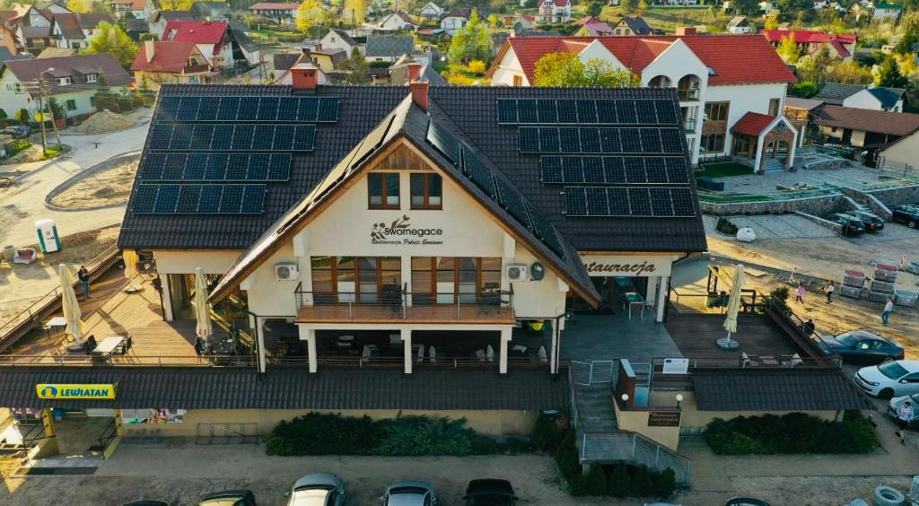 a house with solar panels on top of it at Szklarnia Restauracja i Pokoje Gościnne in Swornegacie 