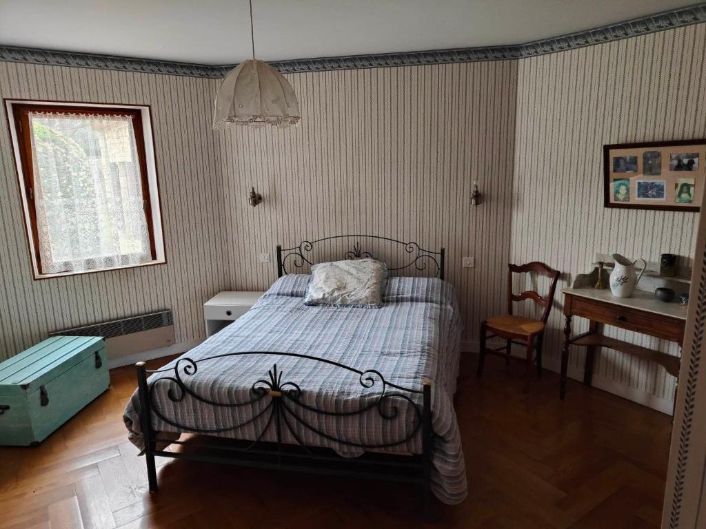 Un pat sau paturi într-o cameră la Chambres chez l'habitant