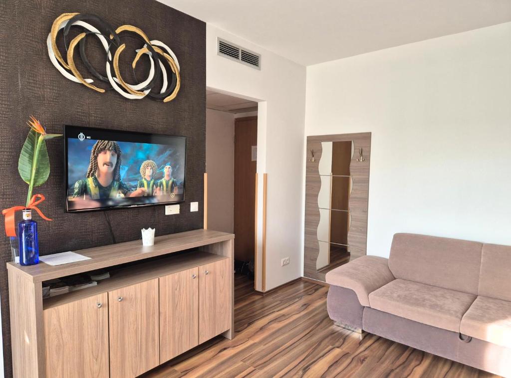 salon z kanapą i telewizorem z płaskim ekranem w obiekcie Manna Wellness Apartman Zalakaros w Zalakaros