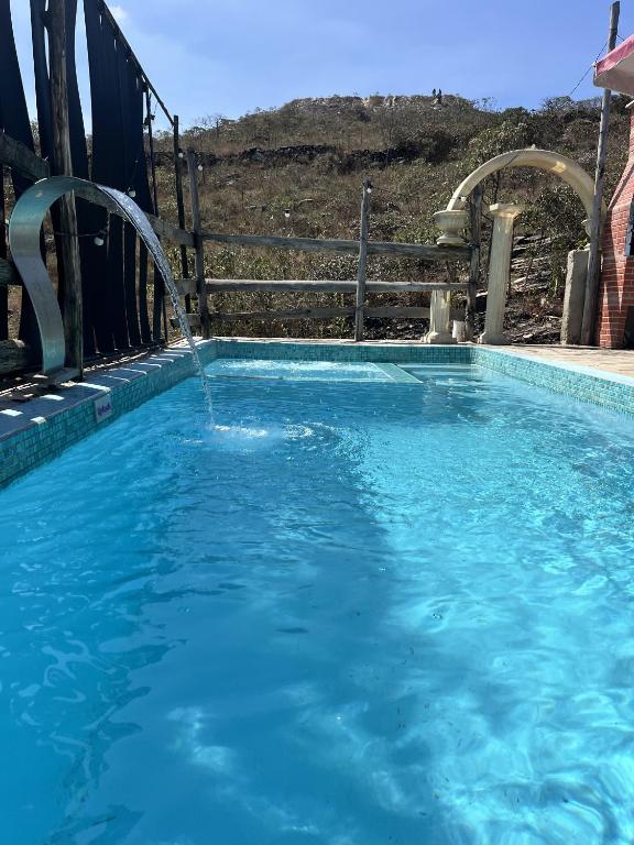 a large swimming pool with a water fountain at Mistica Cama e Café in São Thomé das Letras