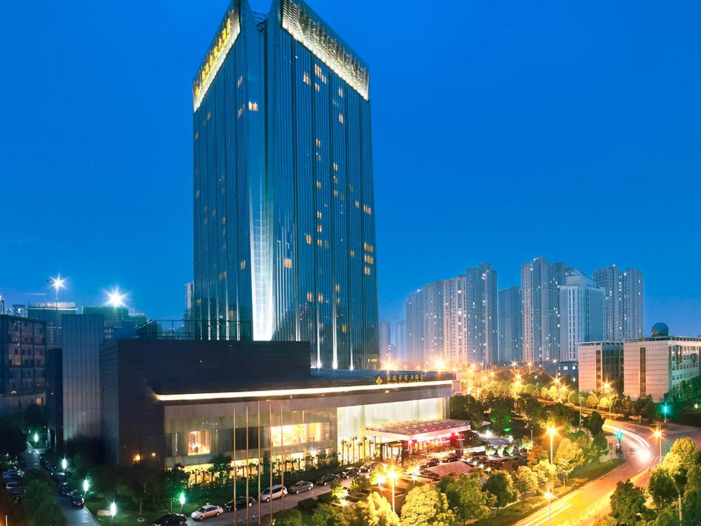 eine Skyline der Stadt in der Nacht mit einem hohen Gebäude in der Unterkunft Hongrui Jinling Grand Hotel Hefei in Hefei