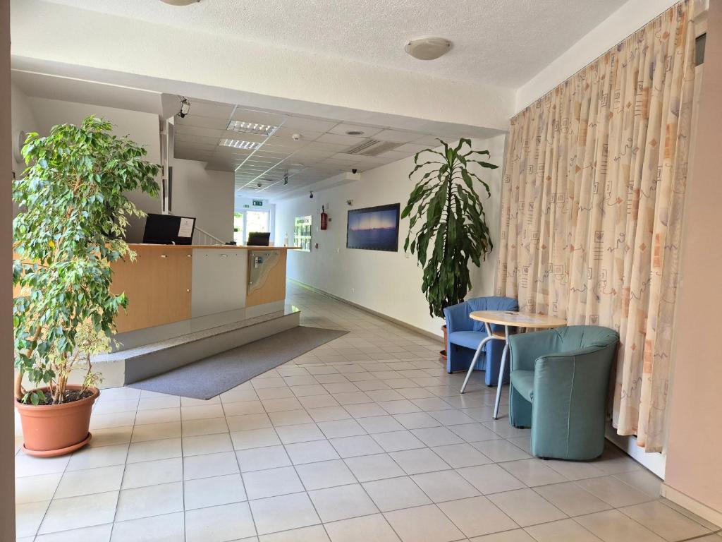 poczekalnia w szpitalu ze stołem i krzesłami w obiekcie Manna Wellness Apartman Zalakaros w Zalakaros