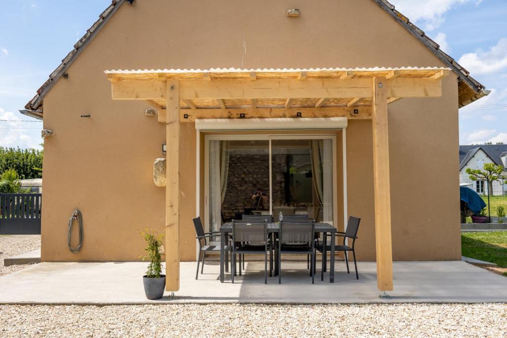 a table and chairs under a pergola on a patio at Gîte du Maron in Mâron