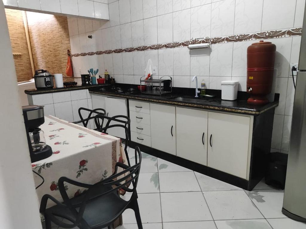 a kitchen with a counter and a table in it at Temporada em Piúma in Piúma