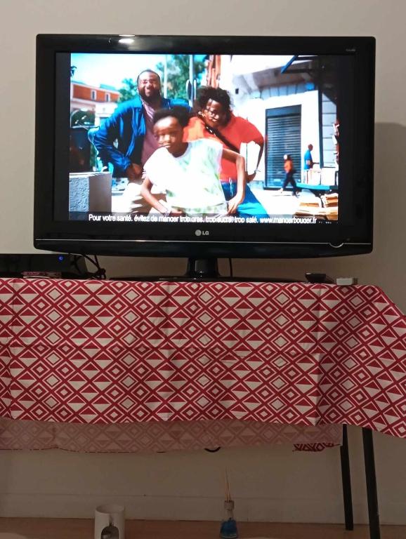 un téléviseur à écran plat posé sur une table dans l'établissement Luxury apartment, à Gagny