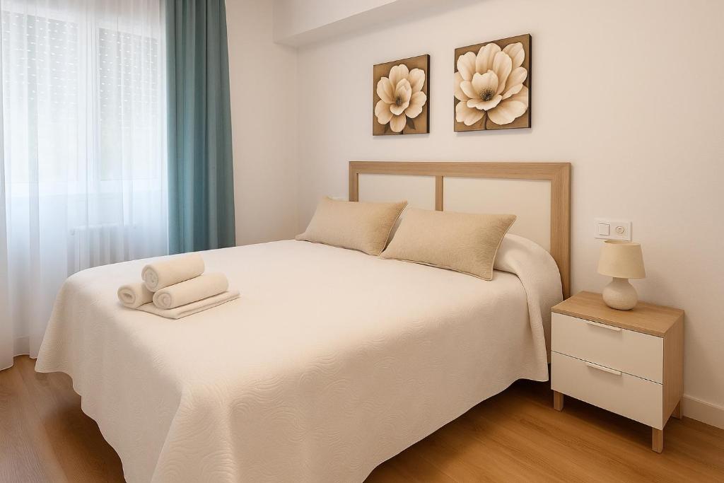 a bedroom with a white bed with two towels on it at Alojamiento Baeza - El Limonero A in Baeza