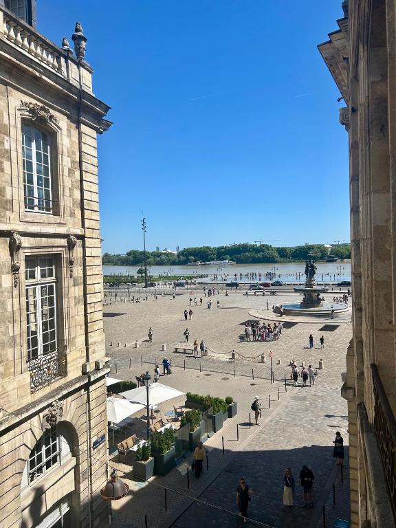 un groupe de personnes se promenant sur une place dans une ville dans l'établissement Appartement rénové Bourse, à Bordeaux